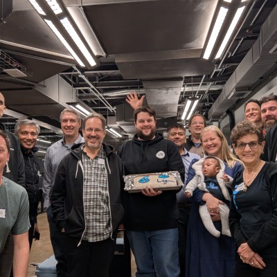 Photo of the attendees of the Austin Drupal CMS Launch Party with a cake
